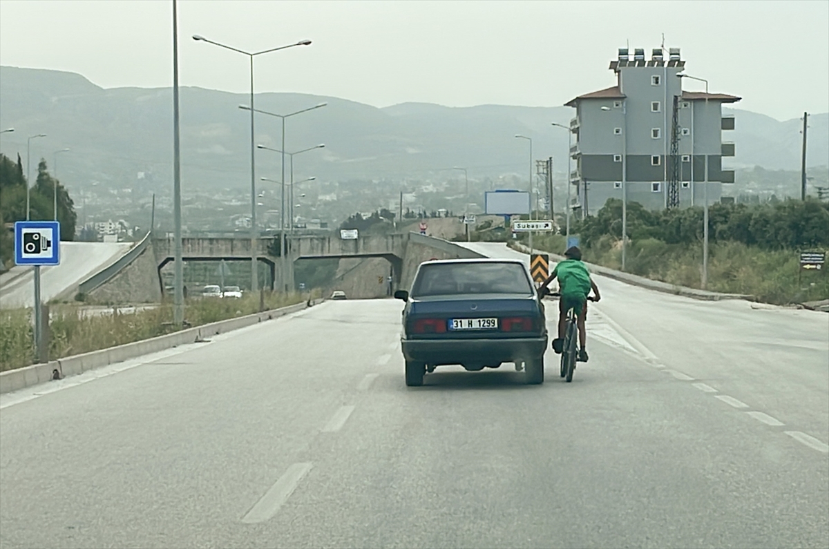 Hatay'da otomobile tutunarak giden bisikletlinin tehlikeli yolculuğu kamerada