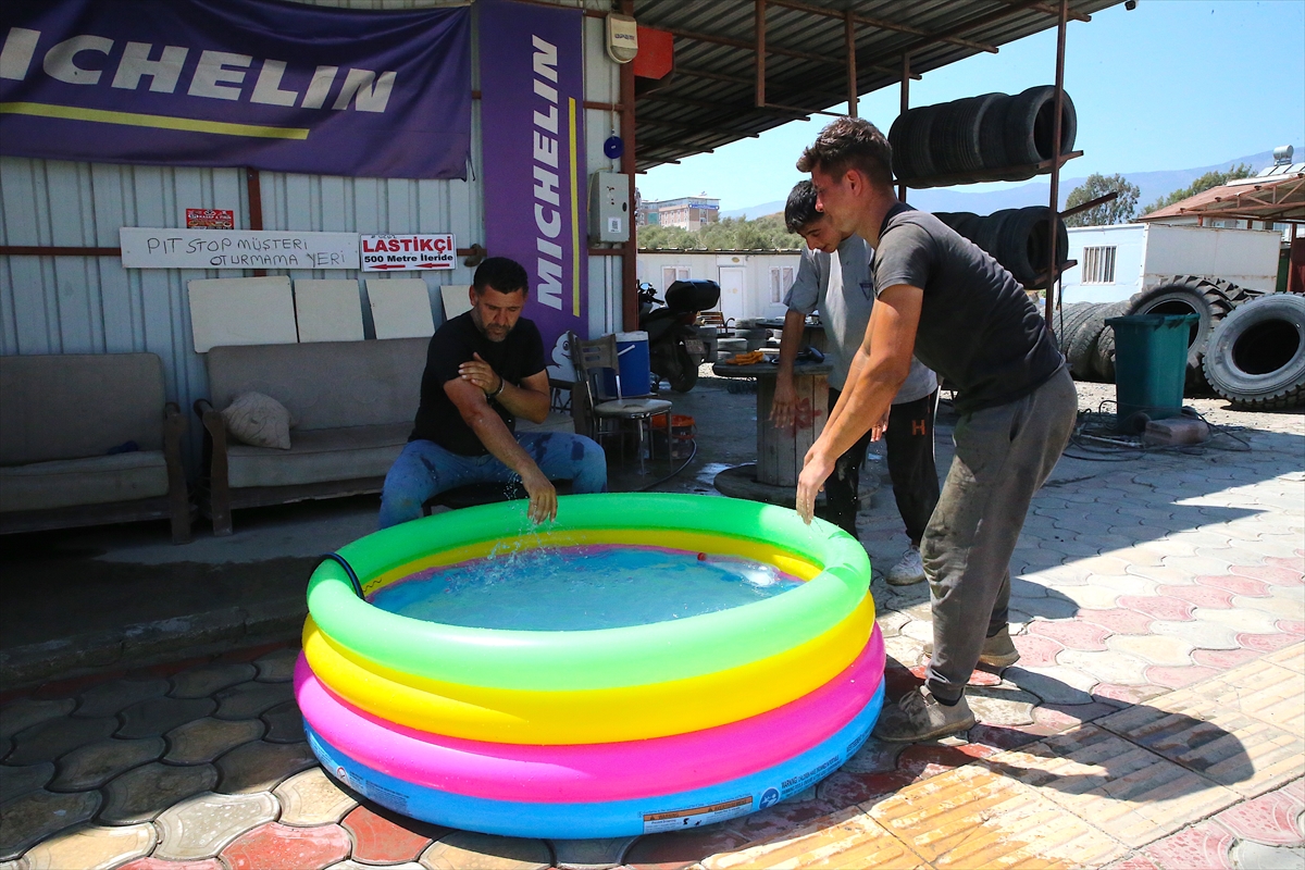 Hatay'da sıcaktan bunalan esnafın doldurduğu şişme havuzda çocuklar da serinliyor