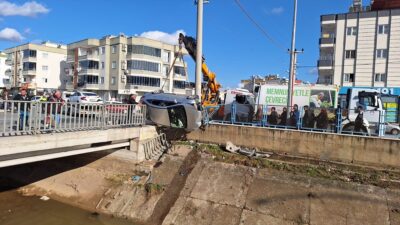 - Kazada sulama kanalının korkuluklarını yıkarak asılı kalan otomobil vinçle